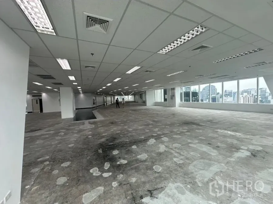 Office Space for rent - Deep floor plate with ceiling air vents, fluorescent fixtures and broad window line.