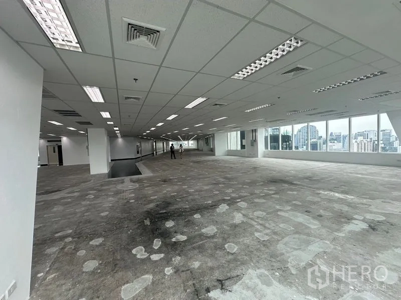 Office Space for rent - Deep floor plate with ceiling air vents, fluorescent fixtures and broad window line.