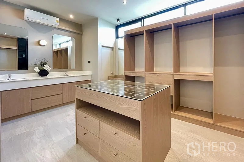 联排别墅 出售在Khlong Toei, Bangkok - 大型步入式衣帽间，设有中岛、双台盆与定制柜体。