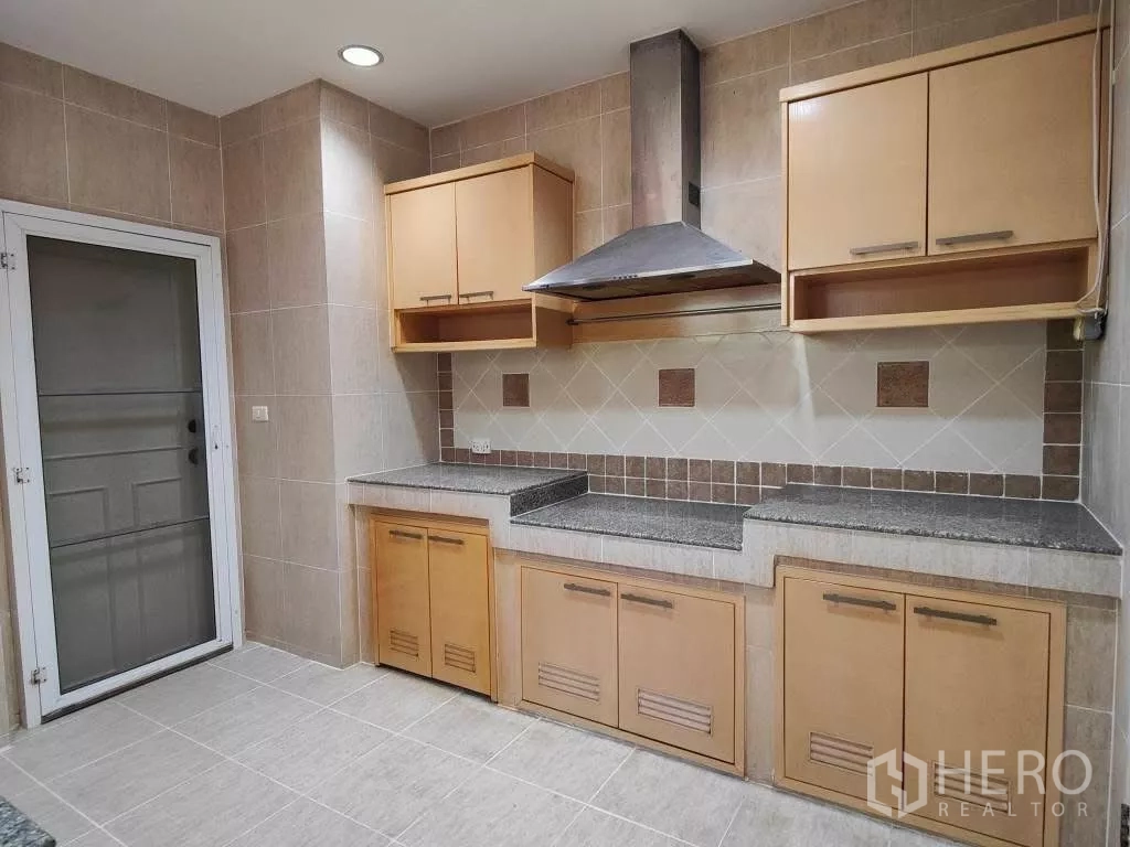 独立式住宅 出租或出售在Mueang Nonthaburi, Nonthaburi - 主厨房，瓷砖墙面，花岗岩台面，橱柜与抽油烟机。