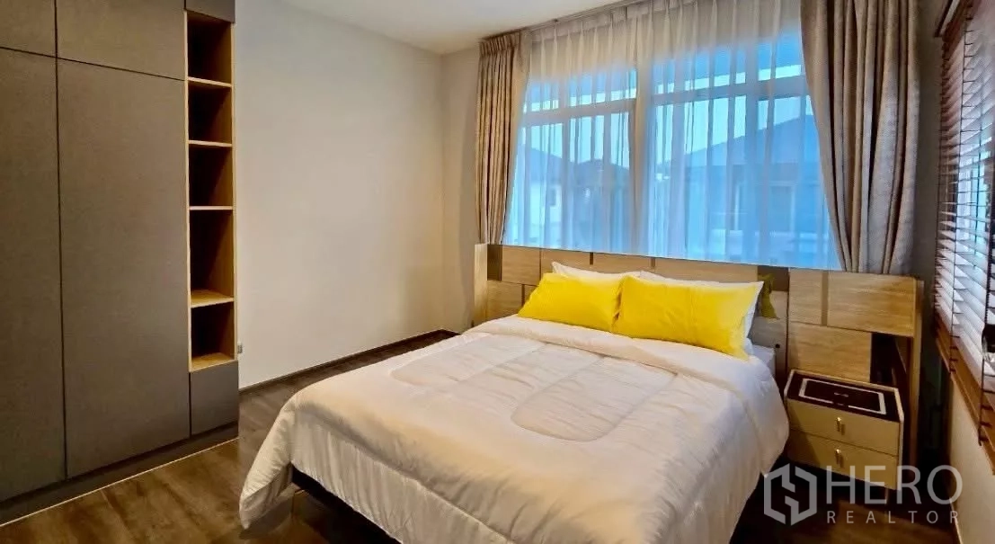 Detached House for rent in Samut Prakan - Guest bedroom with double bed, large window and fitted wardrobe.