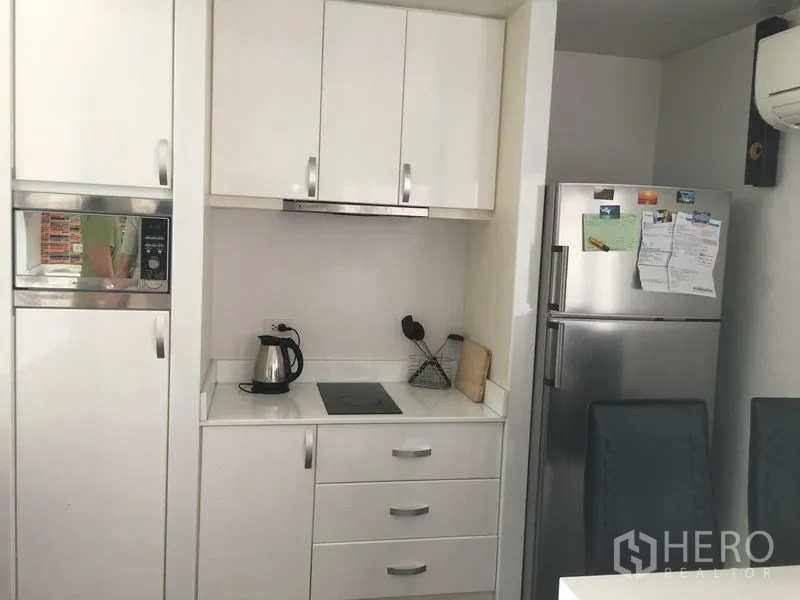 คอนโด ให้เช่าในWatthana, Bangkok - มุมครัวอีกด้าน ตู้ครัวสีขาว เตาไฟฟ้า และตู้เย็นสแตนเลส