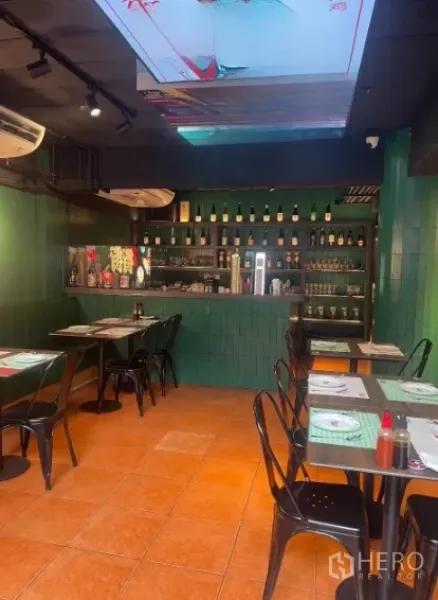 店屋 出租在Watthana, Bangkok - 餐厅式用餐区，带吧台、绿色瓷砖和摆放整齐的餐桌。