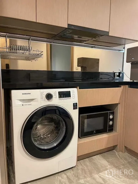 คอนโด ขายในWatthana, Bangkok - ครัวขนาดกะทัดรัด เคาน์เตอร์หินสีดำ เครื่องซักอบ ไมโครเวฟ และตู้เก็บของ