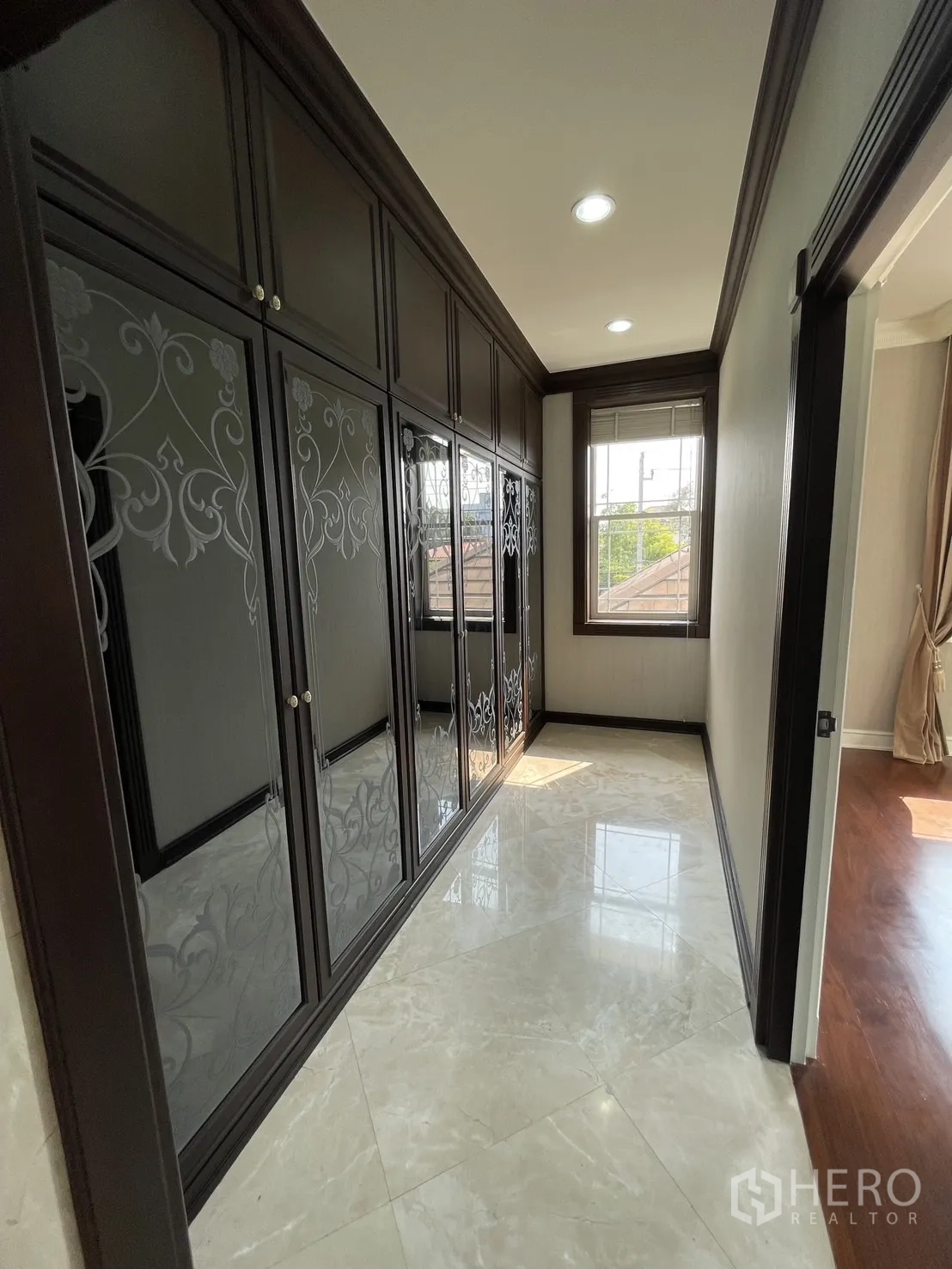 独立式住宅 出租在Chatuchak, Bangkok - 步入式衣帽间走廊，深色柜体与大理石地面