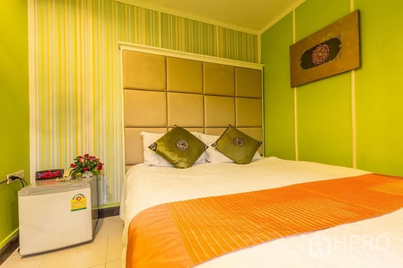 店屋 出租在Phaya Thai, Bangkok - 卧室配软包床头、亮绿色墙面和迷你冰箱，位于曼谷Asok商铺内。