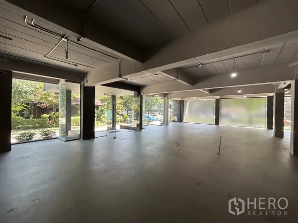 零售空间 出租在Suan Luang, Bangkok - 大面积展厅，环绕玻璃带来自然光与花园景观。