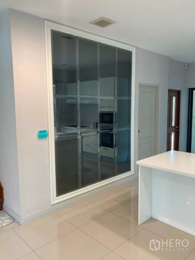 บ้าน ให้เช่าในMueang Nonthaburi, Nonthaburi - ครัวกั้นกระจกมองจากโถงกลาง เห็นเครื่องใช้ไฟฟ้าบิวท์อิน