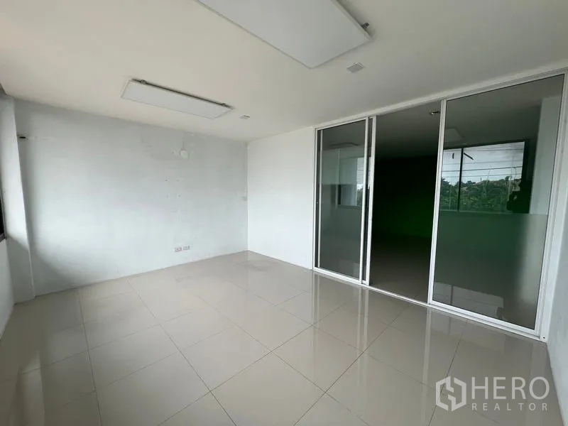 Warehouse for rent in Bang Phli, Samut Prakan - Bright office with ceiling light panels and tinted sliding glass partition.