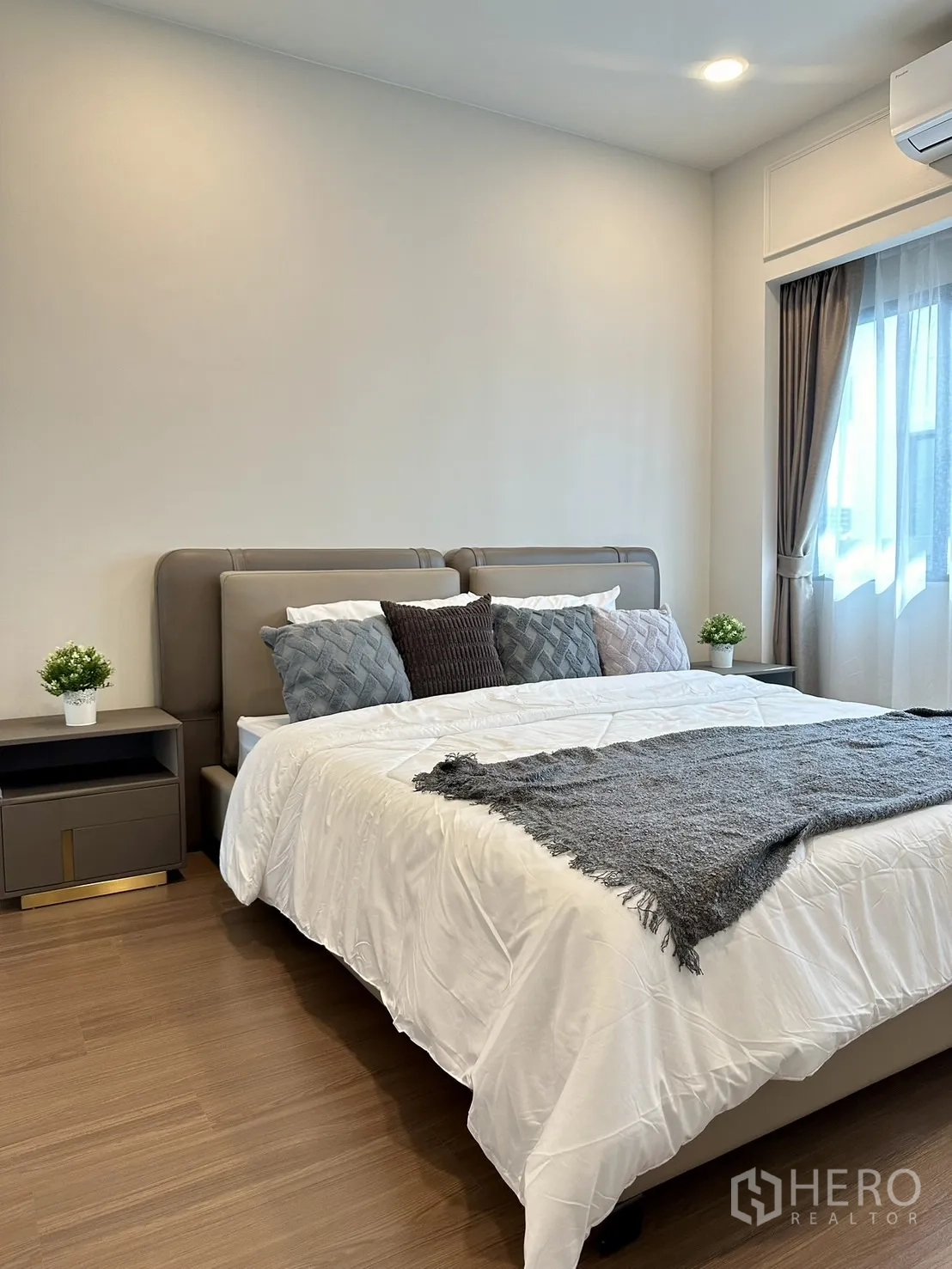 独立式住宅 出租或出售 - 通透明亮的卧室，特大床、床头柜、木地板与窗帘。