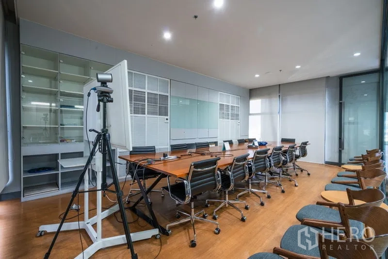 Office Space for rent - Large boardroom featuring long wooden table, swivel chairs, and whiteboard.