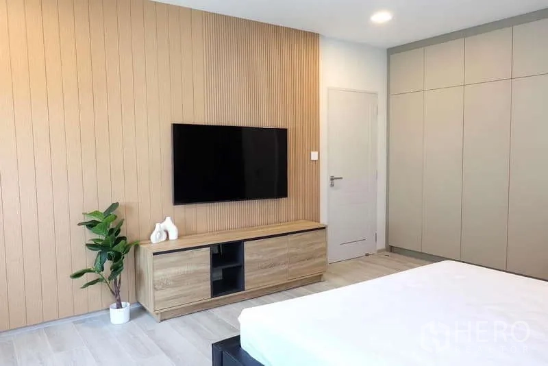 Detached House for rent in Bang Phli, Samut Prakan - Spacious bedroom featuring wood slat accent wall, TV, console and built‑in wardrobes.