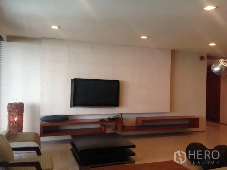 คอนโด ให้เช่าหรือขายในKhlong Toei, Bangkok - ห้องนั่งเล่นสไตล์โมเดิร์นมีทีวีติดผนัง ชั้นลอยไม้ และไฟดาวน์ไลท์ในคอนโดกรุงเทพฯ