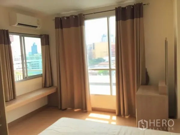 Condominium for rent in Watthana, Bangkok - Bright bedroom with large windows, curtains, air conditioner and city views.