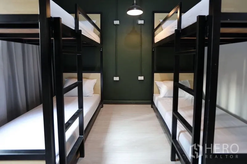 อาคารพาณิชย์ ให้เช่าในKhlong Toei, Bangkok - พื้นที่นอนรวม เตียงสองชั้นโครงเหล็กสีดำ ผนังเน้นสีเขียว