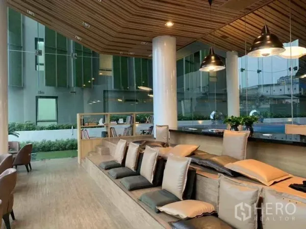 Condominium for sale in Ratchathewi, Bangkok - Co-working lounge with tiered seating, pendant lights and garden views at the condo.