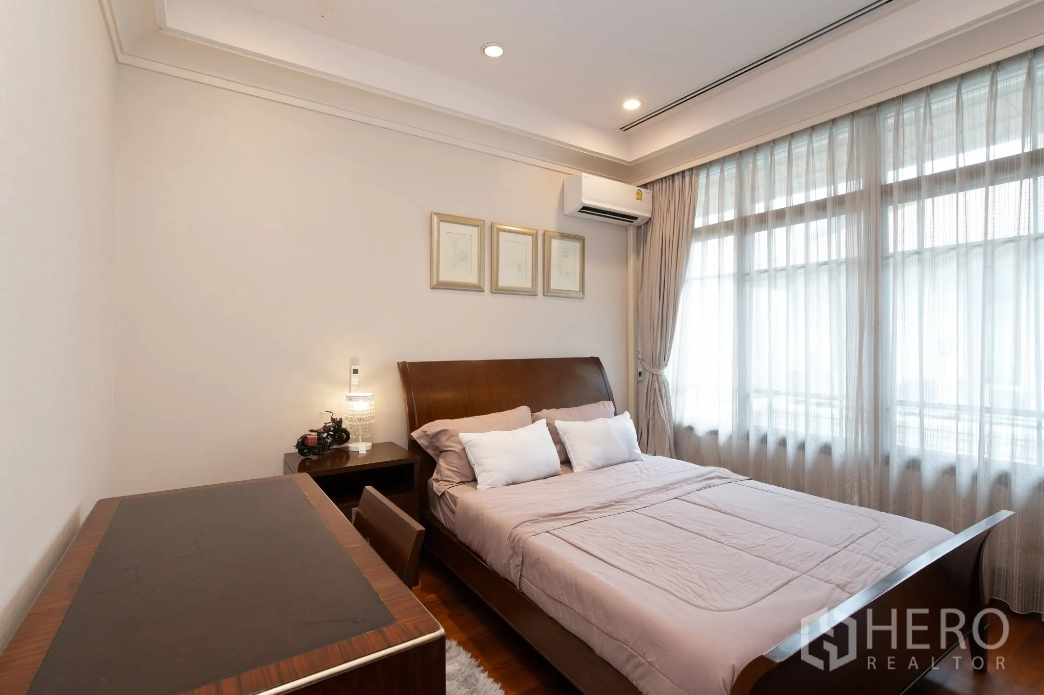 独栋房屋 for rent or sale in Watthana, Bangkok - 客卧配木床与书桌，灯光柔和。
