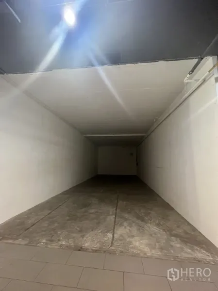 零售空间 出租在Watthana, Bangkok - 狭长店铺毛坯状态，白色侧墙与顶灯照明。