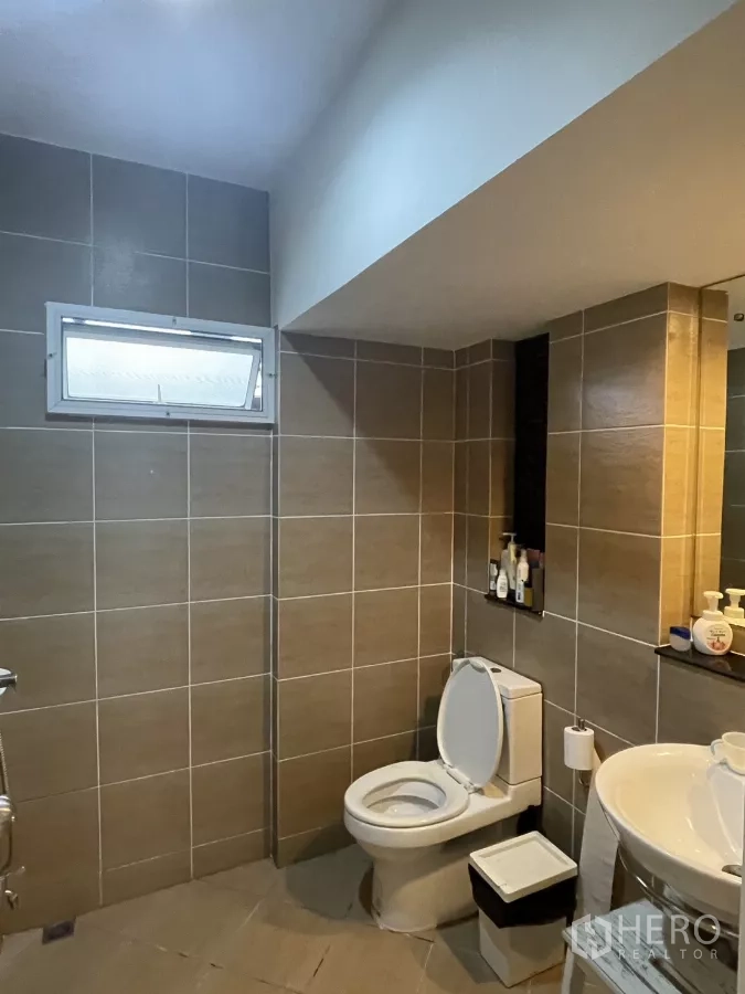 บ้าน ขายในMin Buri, Bangkok - ห้องน้ำที่สองปูกระเบื้องสีเทา กระจกชั้นวาง โถสุขภัณฑ์และอ่างล้างหน้า