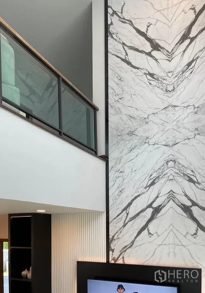 Detached House for rent or sale in Bang Phli, Samut Prakan - Close-up of mezzanine glass railing and dramatic bookmatched marble feature wall.