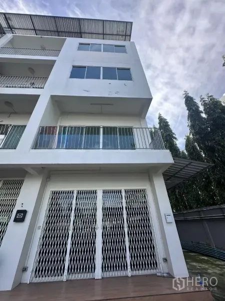 สำนักงานที่บ้าน ให้เช่าในPhra Khanong, Bangkok - อาคารโฮมออฟฟิศ 5 ชั้น สีขาว มีระเบียง หลังคาเมทัลชีท และประตูเหล็กยืดหน้าบ้าน