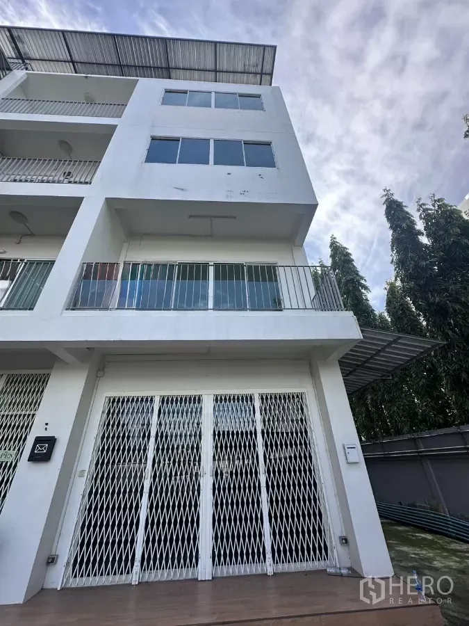 สำนักงานที่บ้าน ให้เช่าในPhra Khanong, Bangkok - อาคารโฮมออฟฟิศ 5 ชั้น สีขาว มีระเบียง หลังคาเมทัลชีท และประตูเหล็กยืดหน้าบ้าน