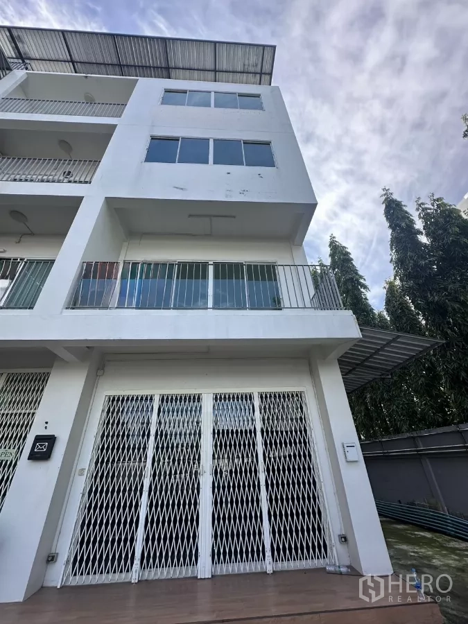 สำนักงานที่บ้าน ให้เช่าในPhra Khanong, Bangkok - อาคารโฮมออฟฟิศ 5 ชั้น สีขาว มีระเบียง หลังคาเมทัลชีท และประตูเหล็กยืดหน้าบ้าน