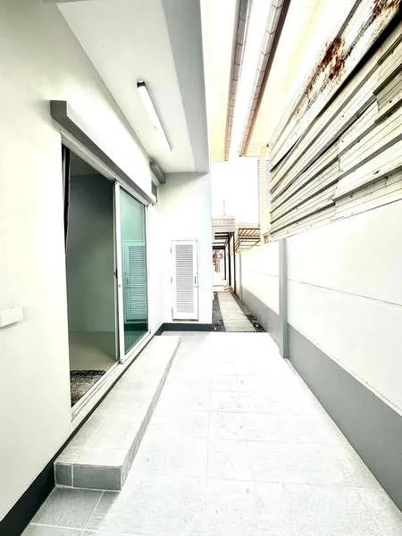 บ้าน ให้เช่าในLat Krabang, Bangkok - ทางเดินข้างบ้านพร้อมประตูกระจกบานเลื่อนและกำแพงสูงเป็นส่วนตัว
