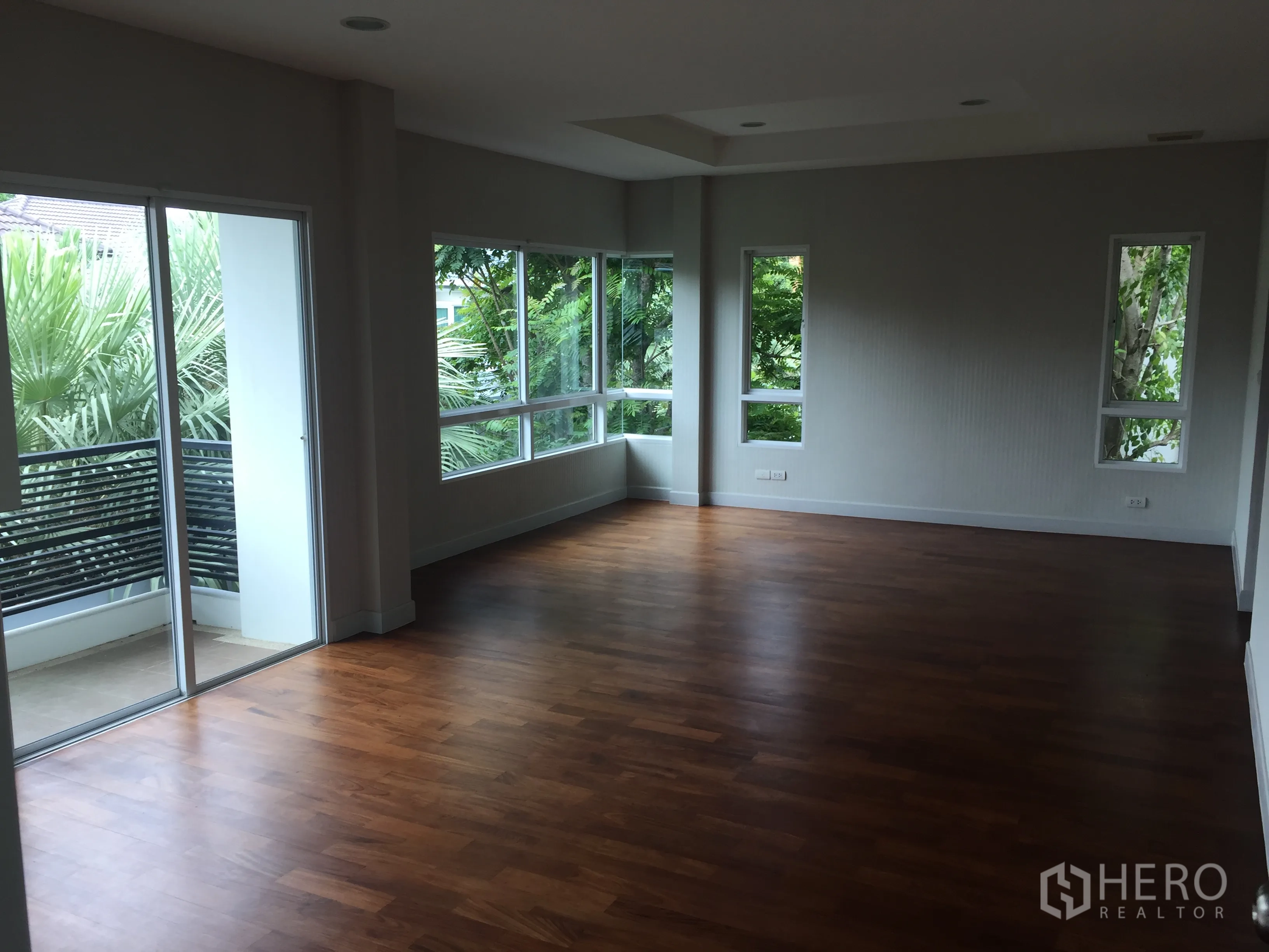 Detached House for sale in Saphan Sung, Bangkok - Large master bedroom with timber floors, corner windows, and balcony access.
