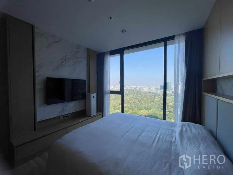 公寓 出租 - 卧室配电视柜与落地窗，眺望公园景。