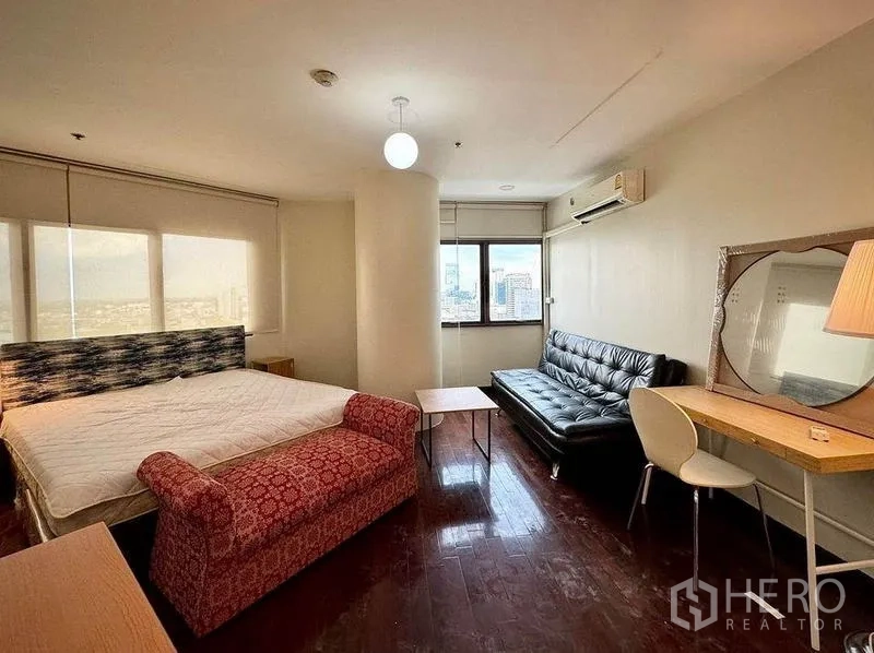 公寓 出租或出售 - 主卧另一角度，黑色沙发、书桌与全景窗外景色。