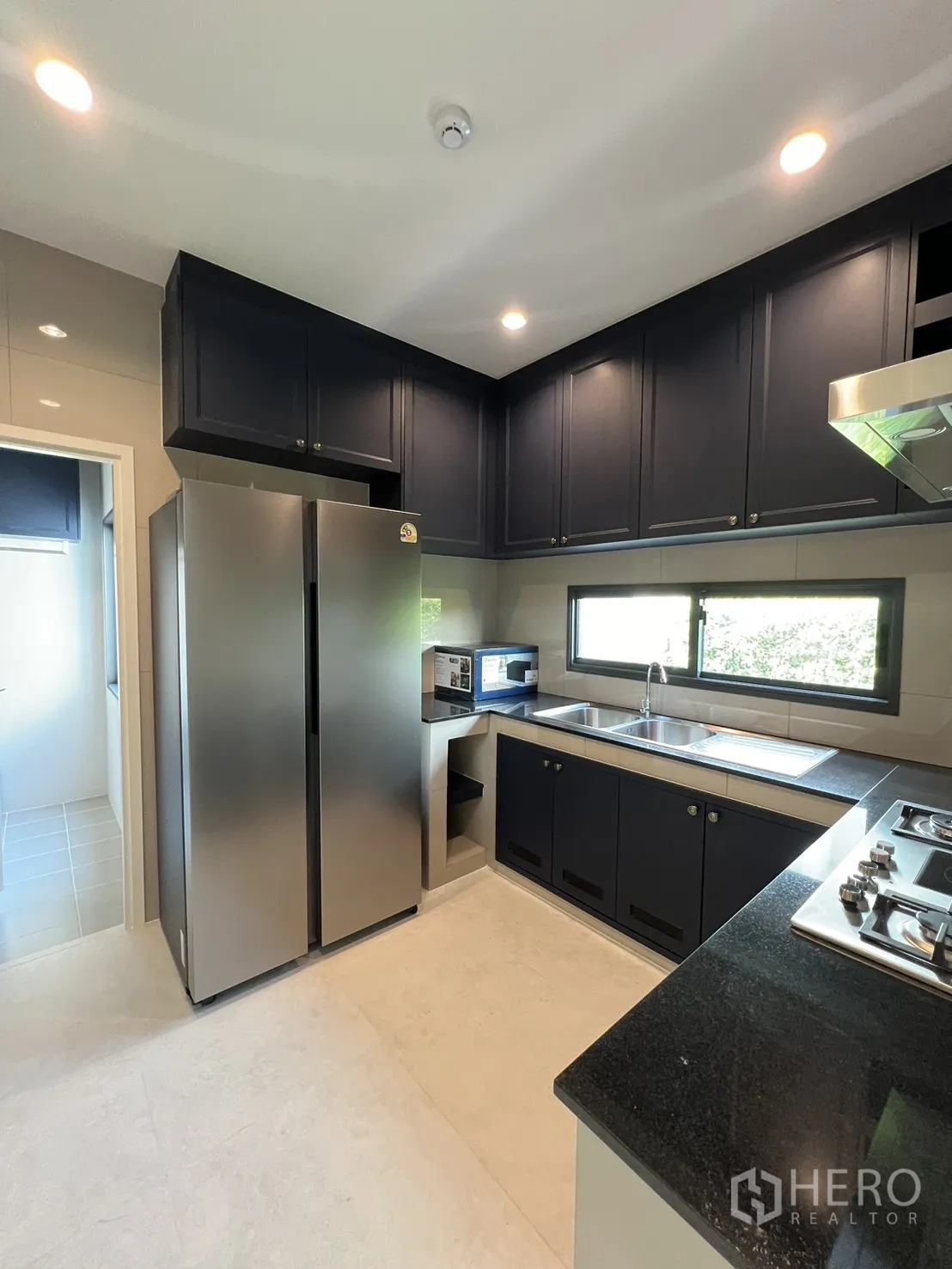 บ้านเดี่ยว for rent in Bang Phli, Samut Prakan - มุมครัวเห็นตู้เย็นสองประตู ช่องวางไมโครเวฟ และตู้แขวนบานตู้สูง