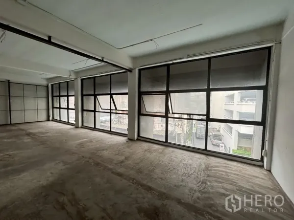 พื้นที่ขายปลีก ให้เช่า - ยูนิตแบบโอเพ่นแปลน พื้นคอนกรีต หน้าต่างกรอบอลูมิเนียมสีดำมองเห็นถนน ภายในสไตล์ลอฟต์