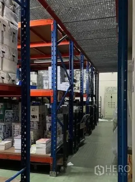 คลังสินค้า ขายในBangkok Yai, Bangkok - ทางเดินโกดังพร้อมชั้นวางพาเลทเหล็กและตาข่ายกันตกด้านบน