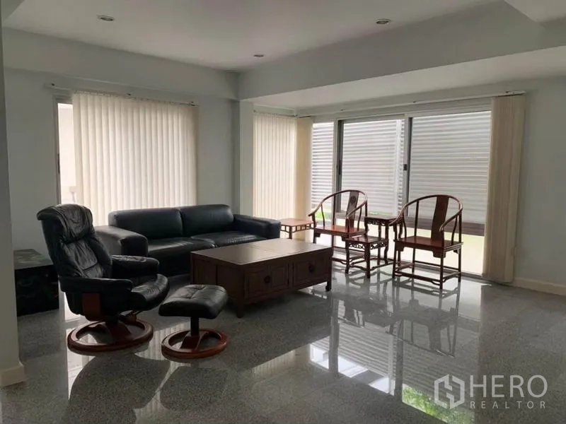 ทาวน์เฮาส์ ให้เช่าในKhlong Toei, Bangkok - ห้องพักผ่อนอีกมุม โซฟาหนัง โต๊ะกลางไม้ และประตูกระจกบานเลื่อน