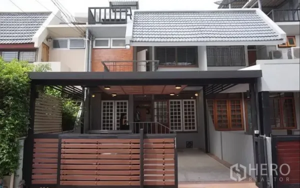 Townhouse for rent in Khlong Toei, Bangkok - Modern three-storey townhouse facade with a gated carport and covered terrace in Phra Khanong.