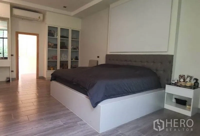 独立式住宅 出售在Pak Kret, Nonthaburi - 宽敞主卧，抬高床台、软包床头与内置柜。