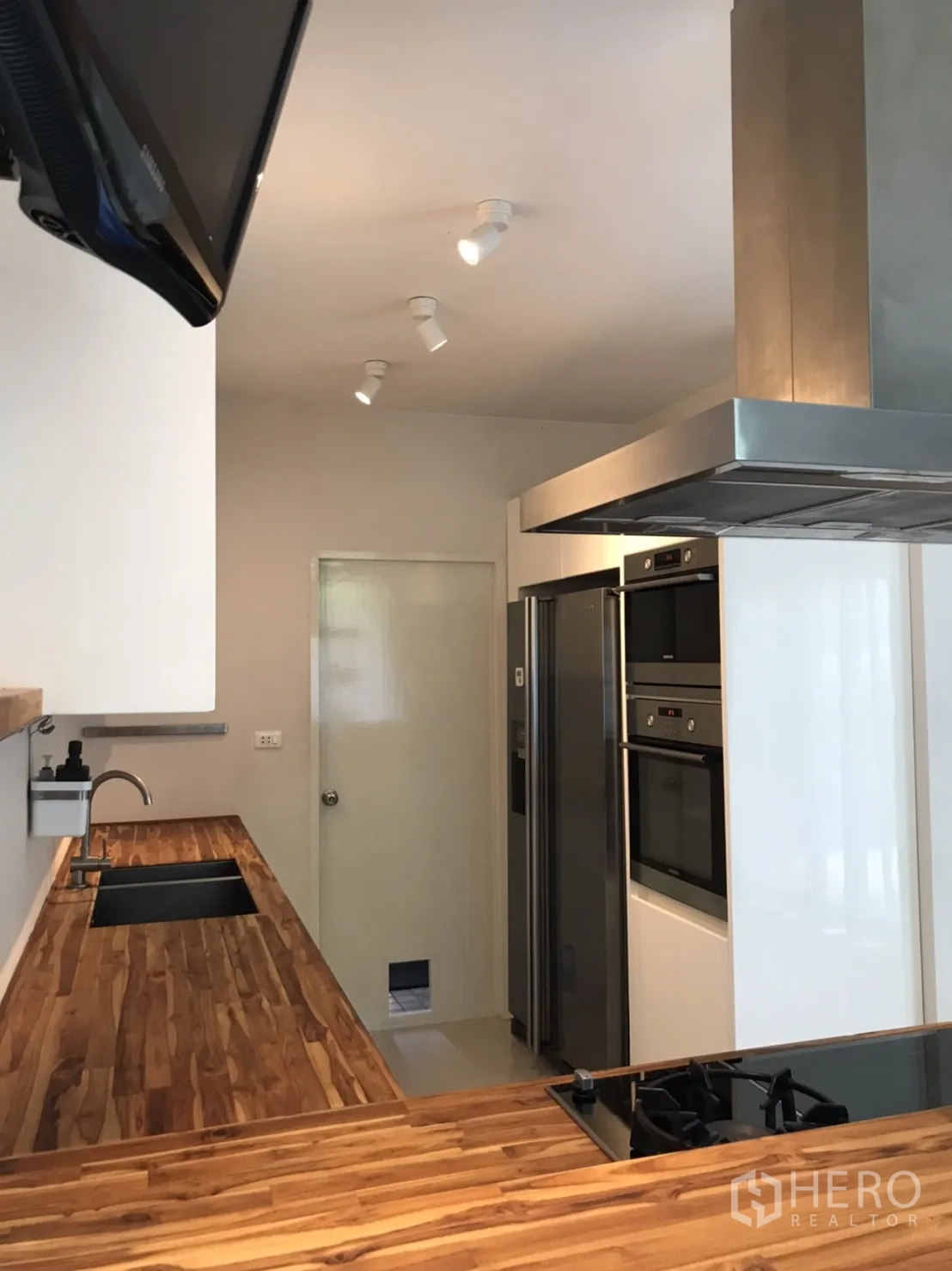 独立式住宅 出租或出售在Saphan Sung, Bangkok - 厨房木质台面，嵌入式烤箱与对开门冰箱。