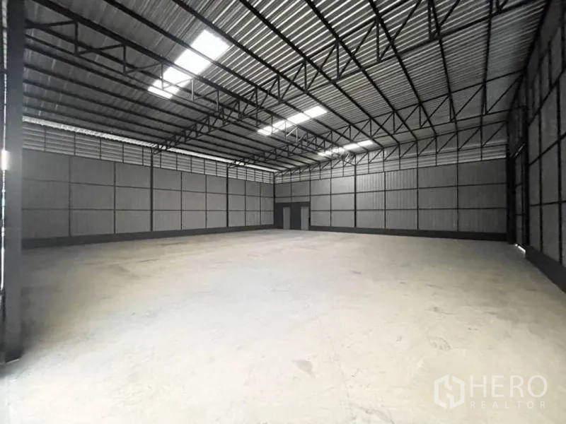 Warehouse for rent in Wang Thonglang, Bangkok - Open-plan storage hall with wide-span beams, ventilated metal walls and bright roof panels.
