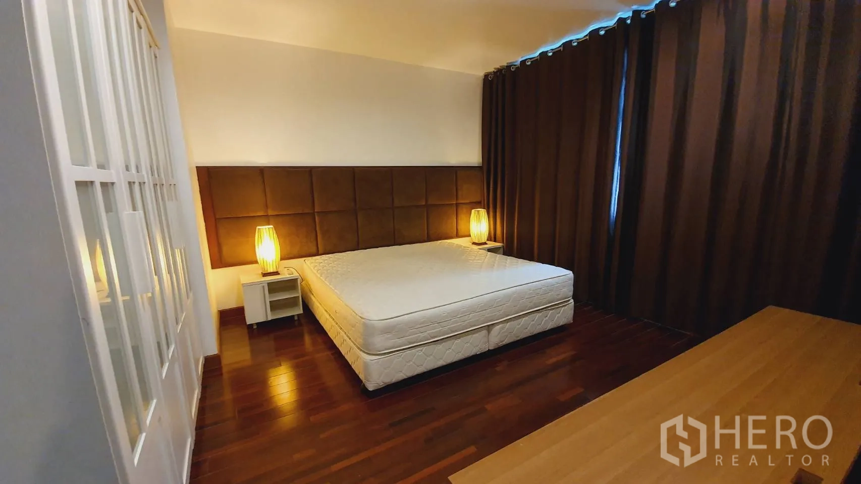 คอนโด ให้เช่าในKhlong Toei, Bangkok - ห้องนอนหลักมีเตียงใหญ่ โคมไฟหัวเตียง ตู้เสื้อผ้า และผ้าม่านสีเข้ม