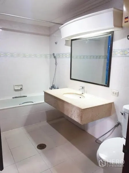 公寓 出租或出售在Watthana, Bangkok - 浴室配浴缸、大镜子与石材台盆。