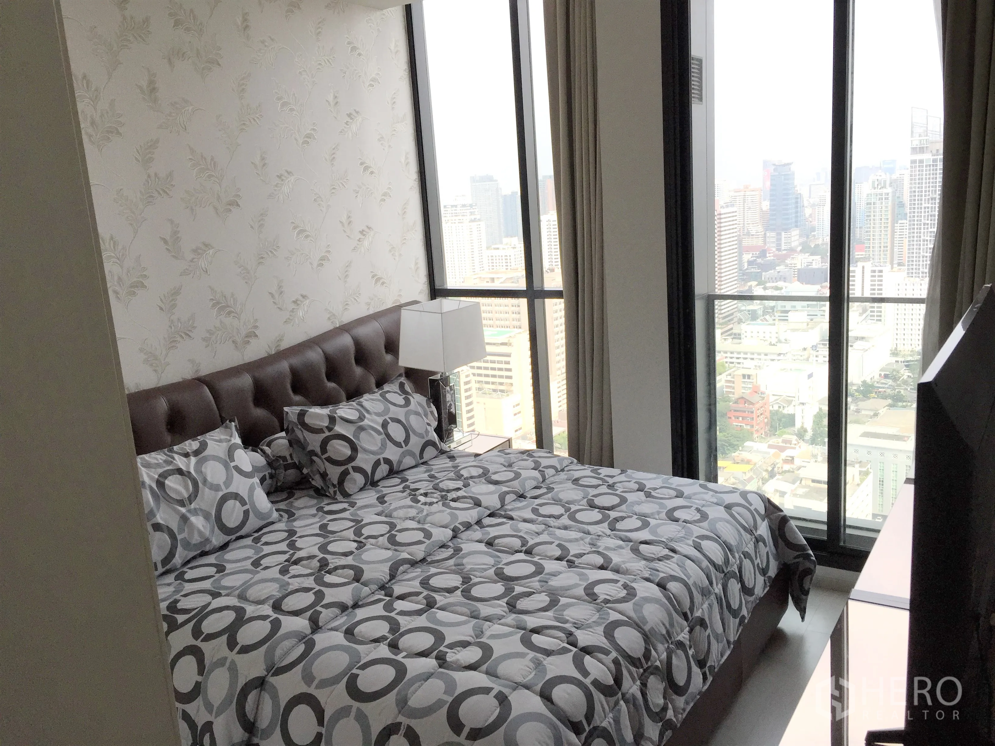 Condominium for rent in Pathum Wan, Bangkok - Master bedroom featuring panoramic city views through floor-to-ceiling glass.