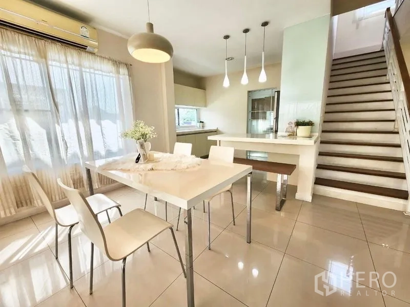 独立式住宅 出租在Prawet, Bangkok - 餐区与备餐台一体，吊灯点缀，毗邻楼梯。