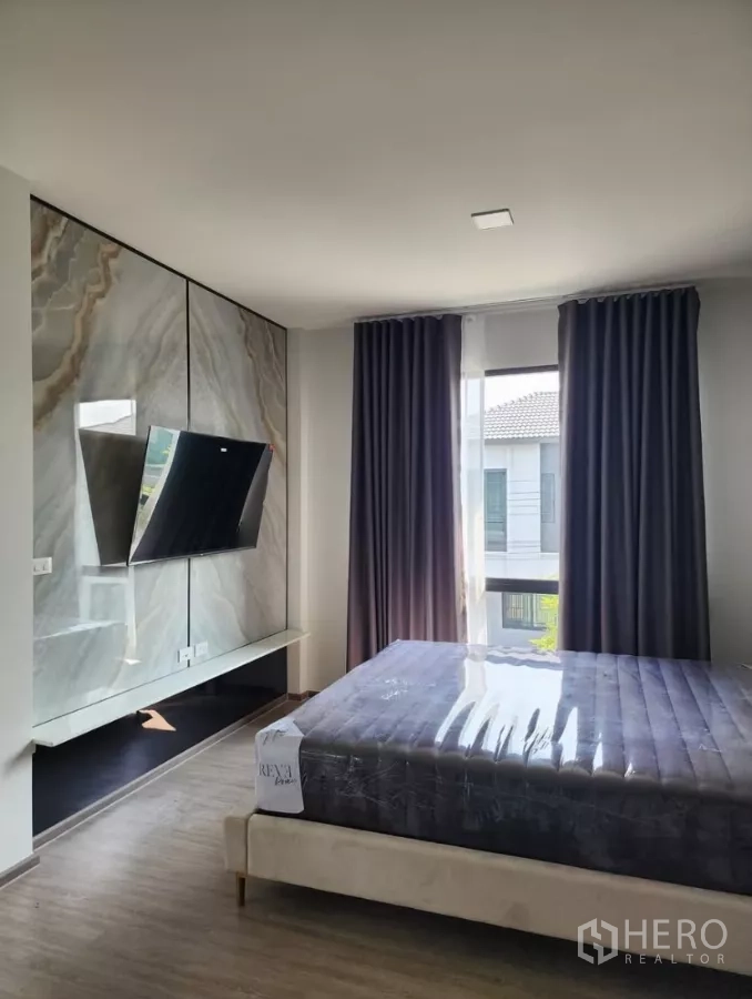 Detached House for rent in Bang Phli, Samut Prakan - Master bedroom with marble TV feature wall, large windows and curtains