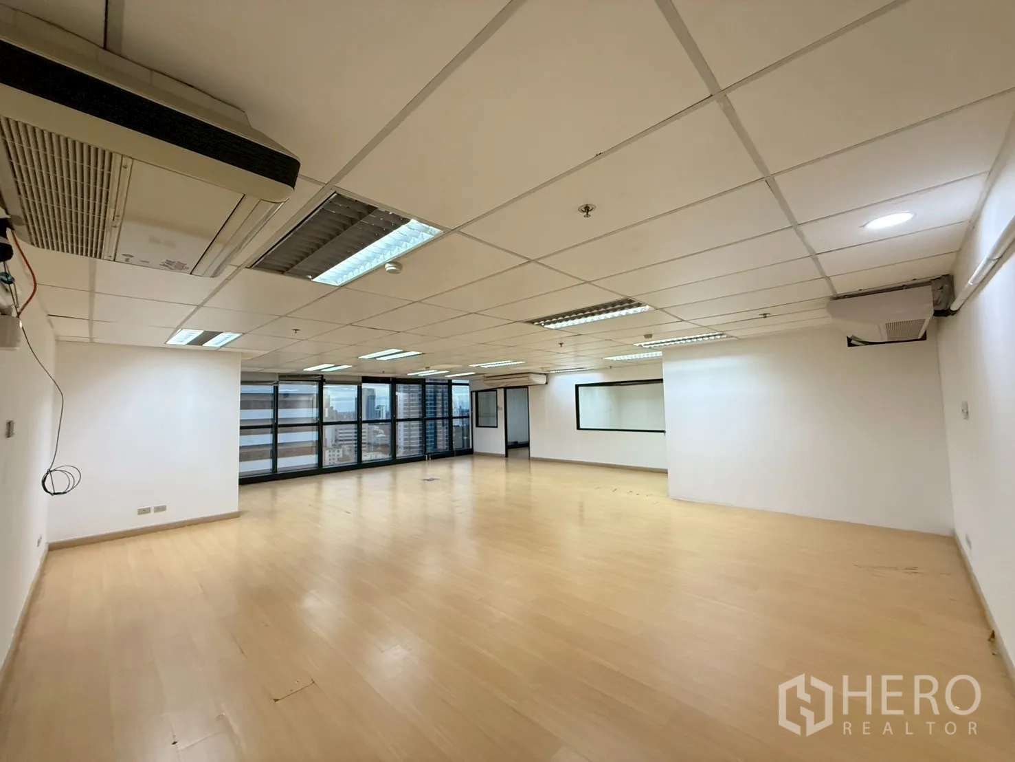 สำนักงาน ให้เช่าในWatthana, Bangkok - โถงออฟฟิศกว้าง ผนังกระจกยาวมองเห็นสกายไลน์ พร้อมเครื่องปรับอากาศติดผนัง