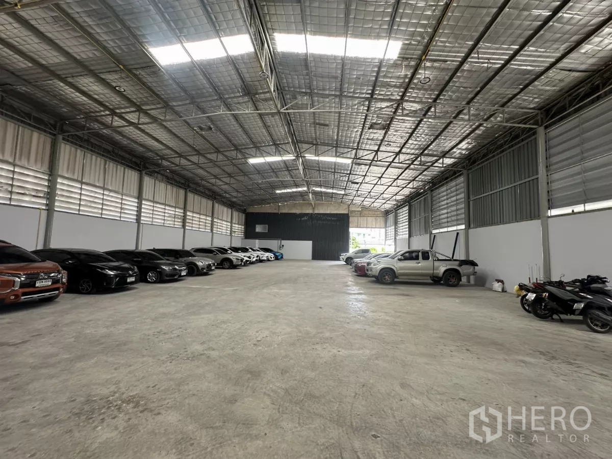 Warehouse for rent in Suan Luang, Bangkok - Spacious column-free warehouse interior with high insulated roof, skylights, and a smooth concrete floor.