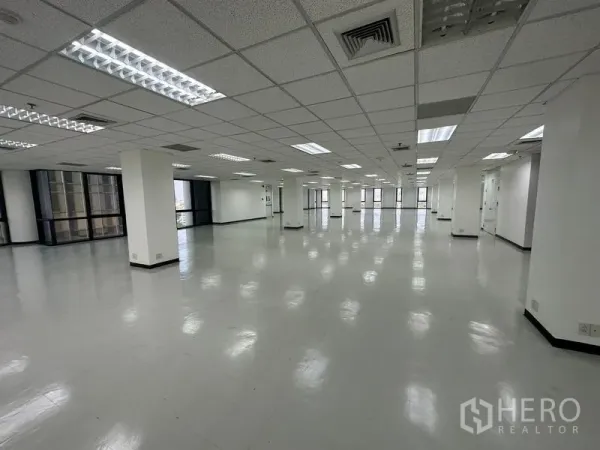 Office Space for rent - Expansive office plate featuring fluorescent troffer lighting and wrap‑around glazing.
