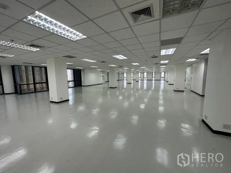 Office Space for rent - Expansive office plate featuring fluorescent troffer lighting and wrap‑around glazing.