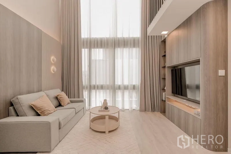 บ้าน ให้เช่า - เลานจ์เพดานสูงสองชั้น ม่านโปร่ง และผนังสื่อบิลท์อิน.