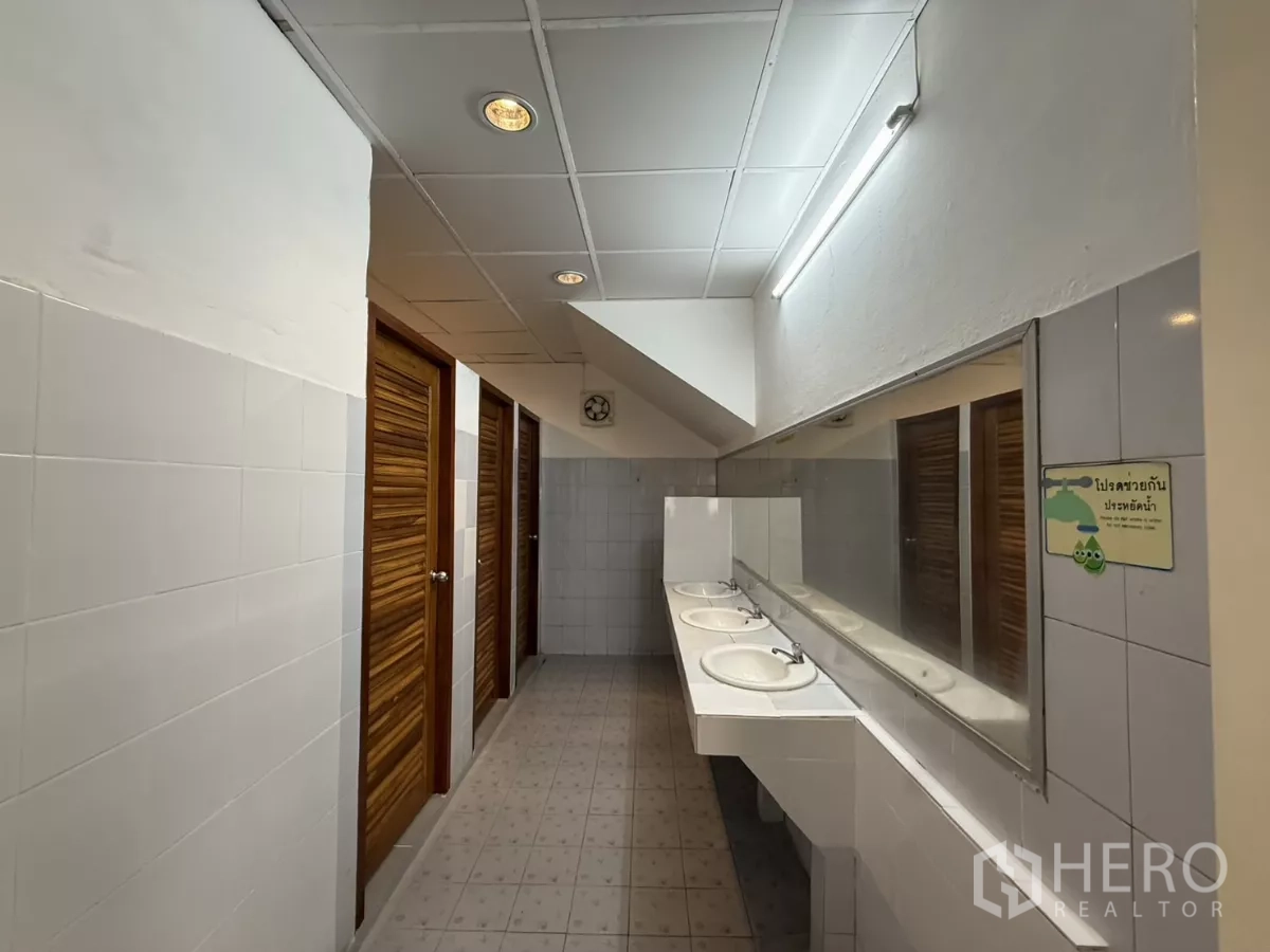 Office Space for rent in Wang Thonglang, Bangkok - Restroom wash area with long mirror, multiple basins and stall doors.